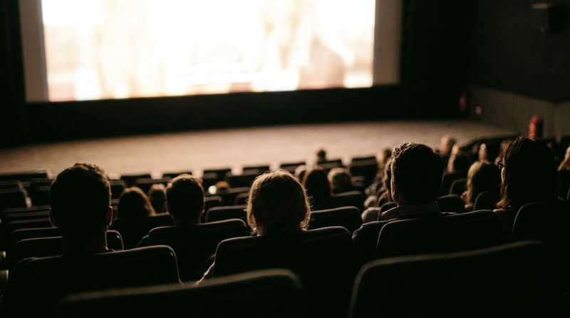 Dark cinema screen seen from the back rows